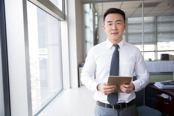 istock young man standing near window in office 667704658