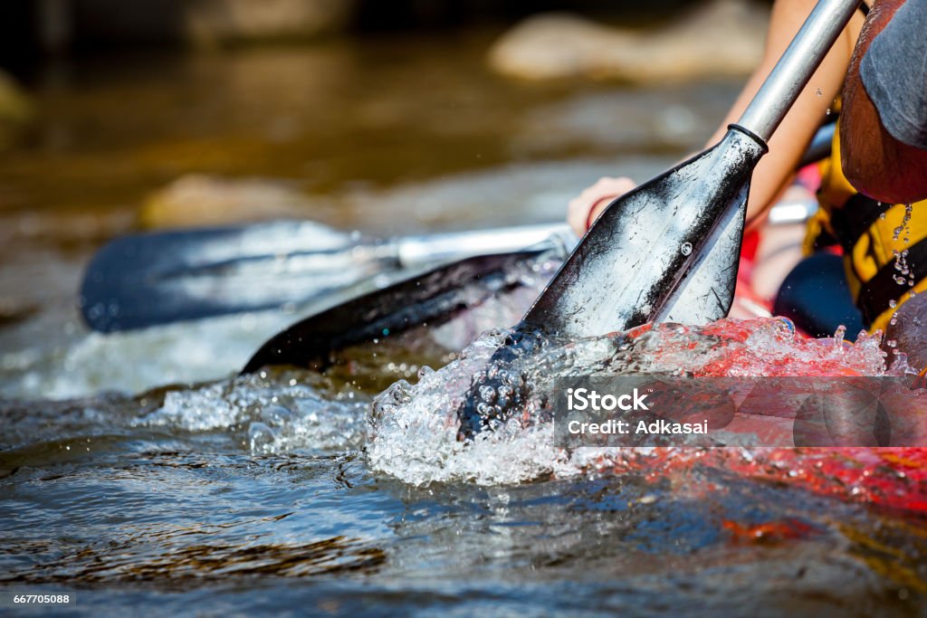 Enfoque parte de la persona joven son rafting en río. - Foto de stock de Remar libre de derechos
