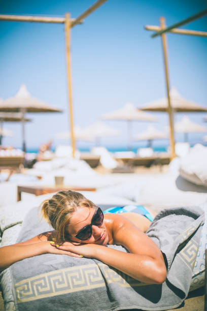 istock Beautiful woman sunbathing relaxing on a beach 667705200