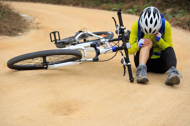istock female cyclist getting injured while falling from mountain bike on forest trail 667708418