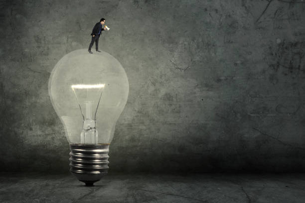 istock Businessman with megaphone on lamp 667708476