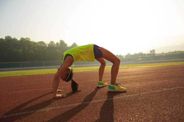 istock young asian woman backbending on stadium track 667708630