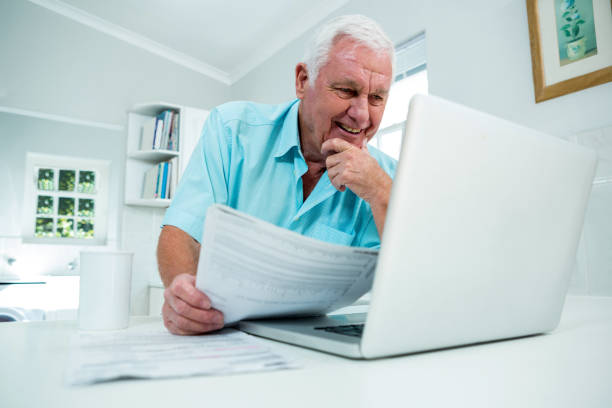 istock Smiling senior man looking into laptop 667709248
