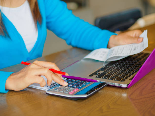 istock woman working with calculator, business document and laptop computer notebook 667711982