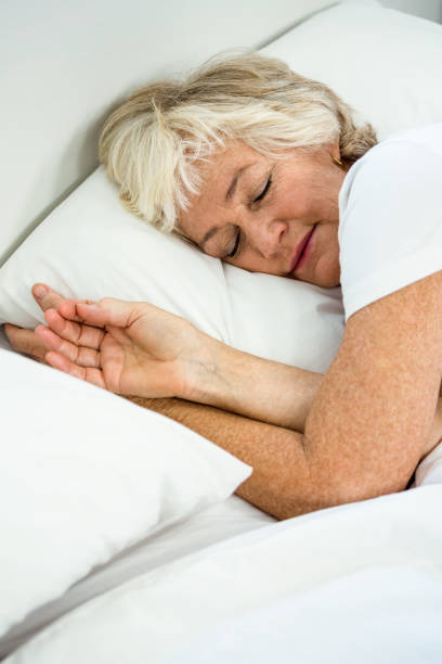 istock High angle view of senior woman sleeping 667712098