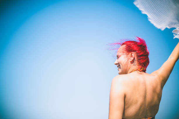 Happy woman in bikini posing on beach