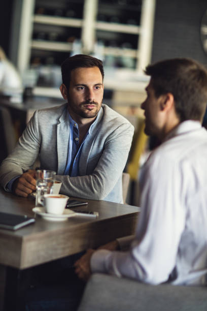 istock Young businessman with colleague having coffee break in a cafe. 667716184