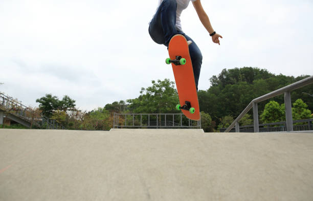 istock skateboarder legs doing a ollie trick at skatepark 667719430