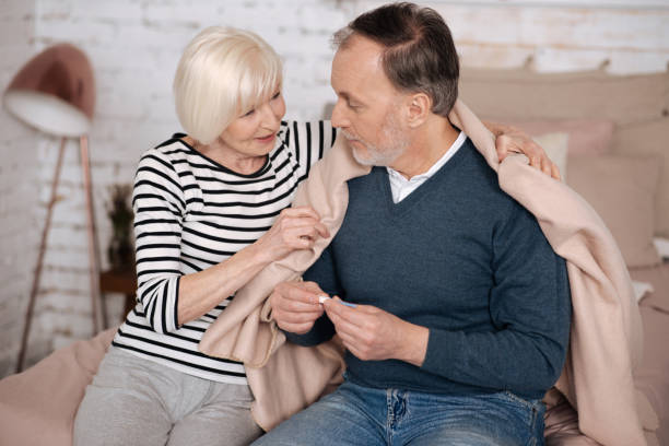 istock Senior lady covering her husband with blanket 667723582