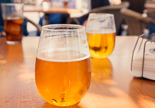 glasses of golden beer outdoor on table outdoor in a bar