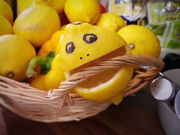 smiley face on lemon in basket - lemon sour taste biting eating zdjęcia i obrazy z banku zdjęć