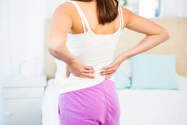 istock Rear view of a woman with back pain 667731464