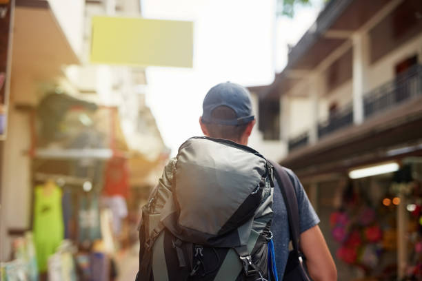 Rearview shot of a young tourist wearing a backpack walking down a city street