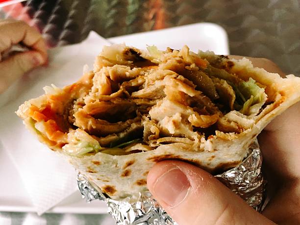istock Cropped Image Of Person Eating Wrap 667733577