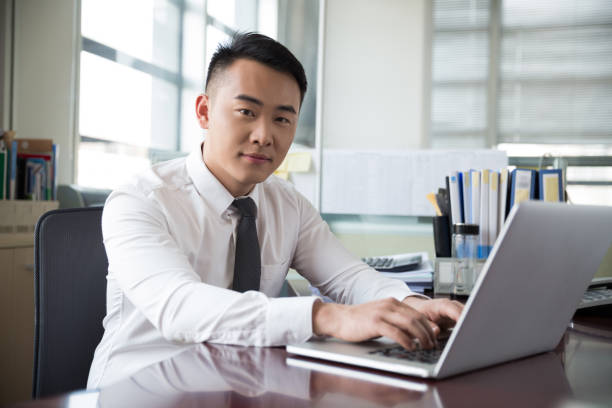 istock young businessman working at laptop in office 667734710