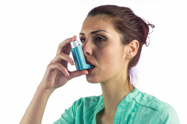 istock Close-up of woman using asthma inhaler 667734810