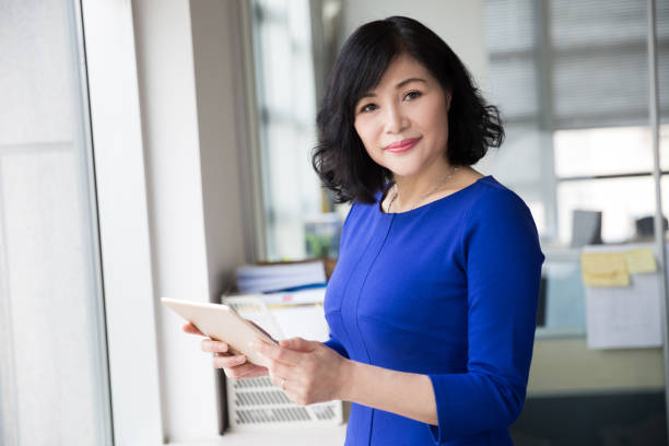 istock middle-aged female manager posing near by window 667737738