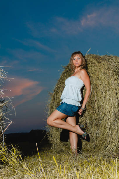 istock Young sexy blonde posing near a haystack 667738404