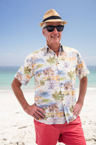 istock Senior man in sunglasses and hat standing on the beach 667743780