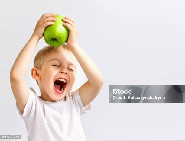 Small Boy Holds A Big Green Apple Stock Photo - Download Image Now - Child, Eating, Fruit