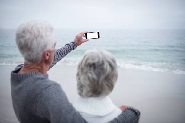 istock Senior couple taking a selfie on the beach 667747658