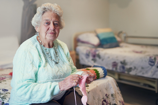 Portrait of a senior woman knitting in an old age home