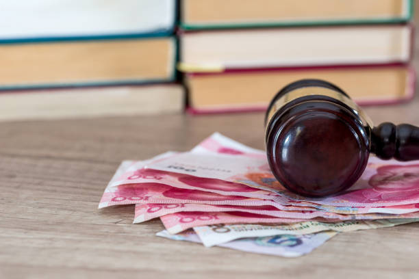 istock wooden gavel with yuan bills close up. 667748542