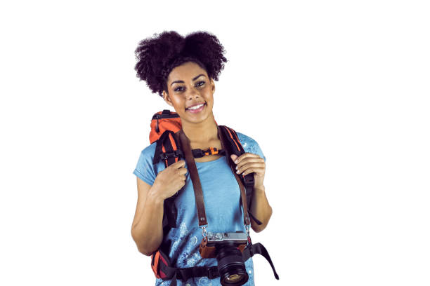 Portrait of a young woman with camera and backpack against a white background