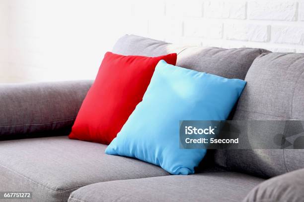Colorful Pillows On Grey Sofa On A Brick Wall Background Stock Photo - Download Image Now