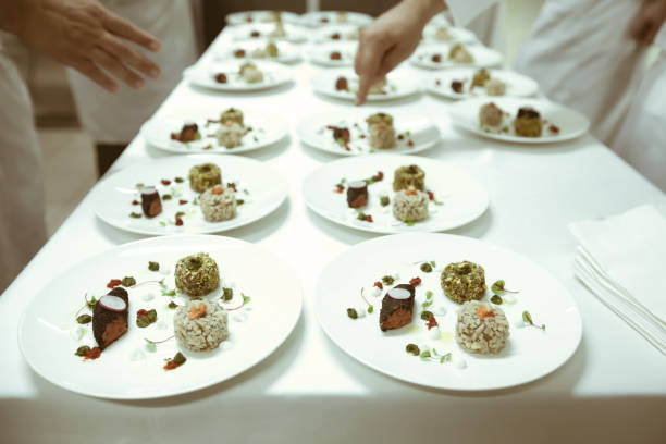 istock chef using chopsticks tong sliced beef put on the white plate in luxury dinner party, Blurry background with vintage color style. 667752366