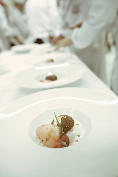 istock chef using chopsticks tong sliced beef put on the white plate in luxury dinner party, Blurry background with vintage color style. 667752438