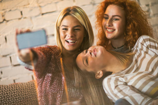 istock Young happy women having fun together while taking selfie. 667759024