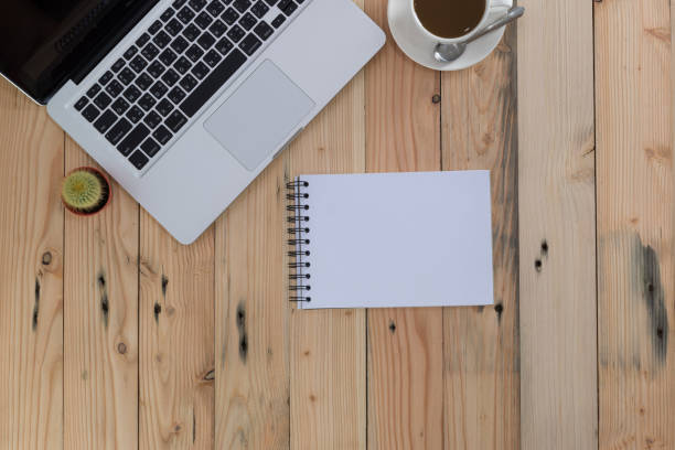 istock office stuff with notepad, laptop, tablet and coffee cup top view shot. 667759176