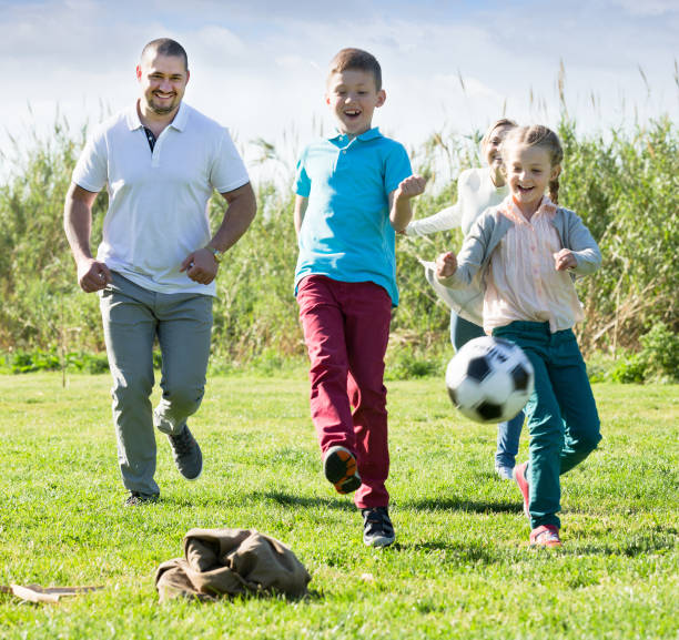 istock Family playing in football 667764126