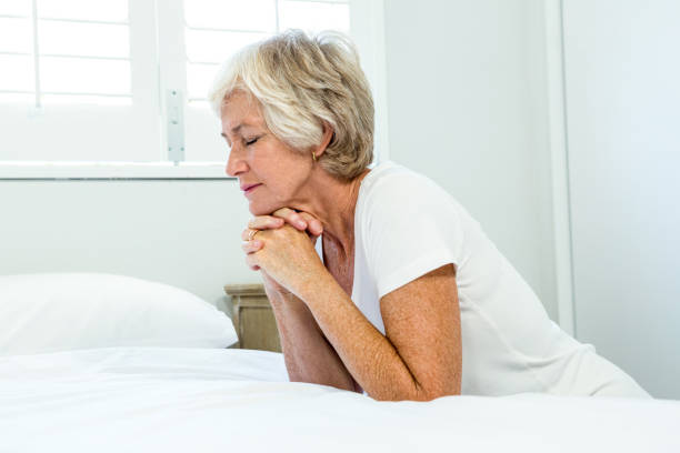 istock Senior woman praying at home 667764194