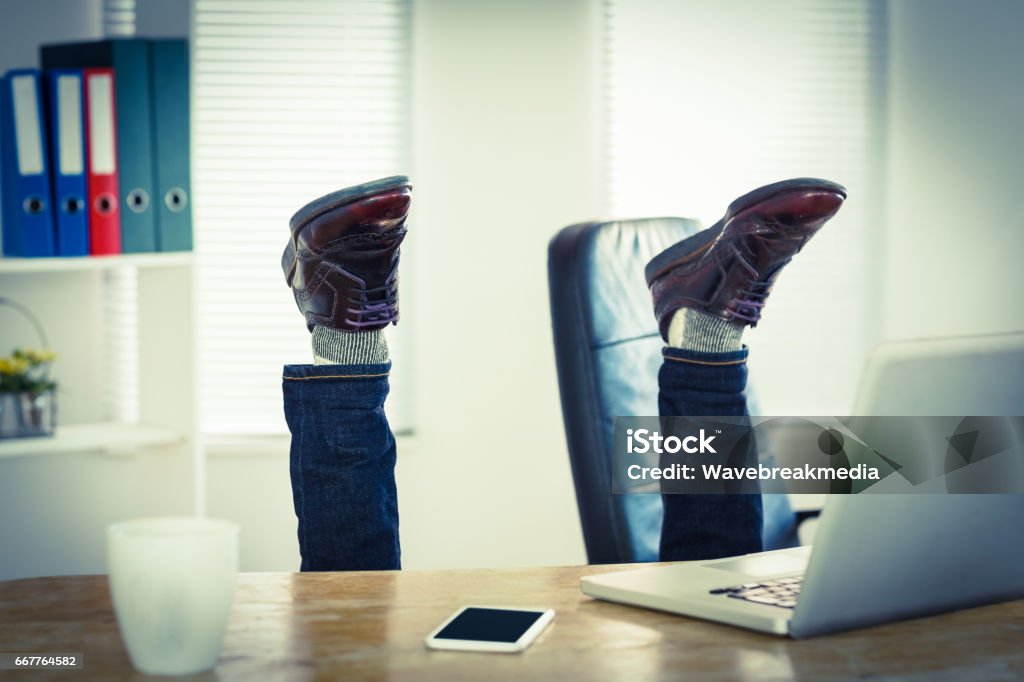 Businessman upside down at his desk Businessman upside down at his desk in his office Upside Down Stock Photo