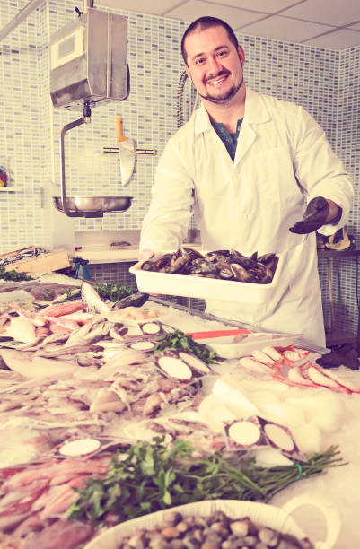 istock smiling man holds in hand container with big mussels 667767238