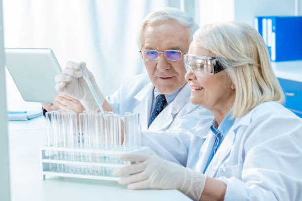 istock Smiling senior chemists working with test tubes in laboratory 667767634