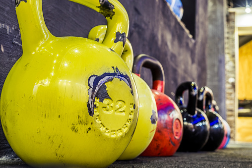 colorful kettlebells in a row in a gym, organized and put away
