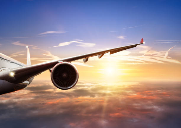 istock Wing of airplane flying above clouds in sunset light 667771504