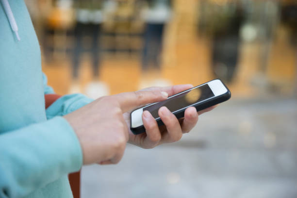 istock hands use smartphone  front of shopwindow 667777394