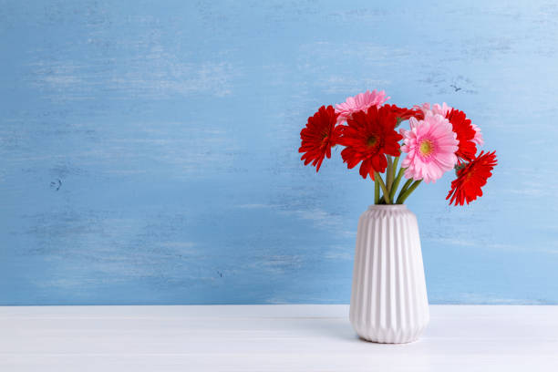 istock Gerbera flowers in vase on wooden background. 667794642