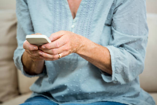 istock Midsection of senior woman using mobile phone 667794762