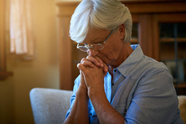 вы никогда не одиноки, если у вас есть вера - praying women senior adult spirituality стоковые фото и изображения