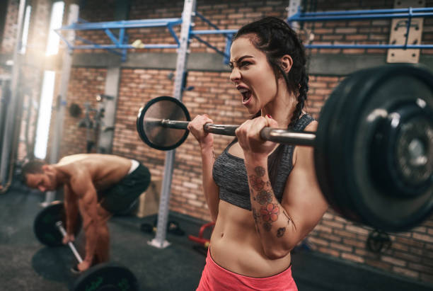 istock Fit couple lifting barbells in the gym 667807064