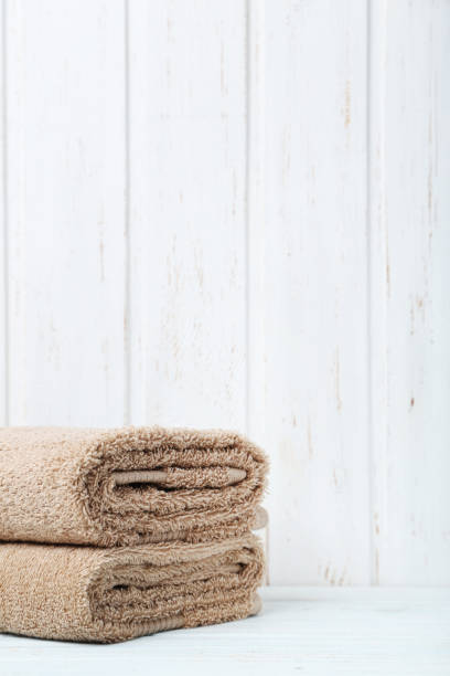 istock Beige towels on white wooden table 667810104