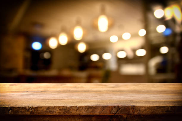 istock wooden table in front of abstract restaurant lights background 667813536
