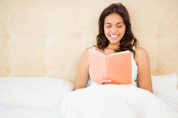 istock Pretty woman reading book in her bed 667817068