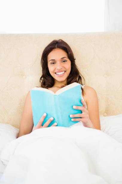 istock Pretty woman reading book in her bed 667817284