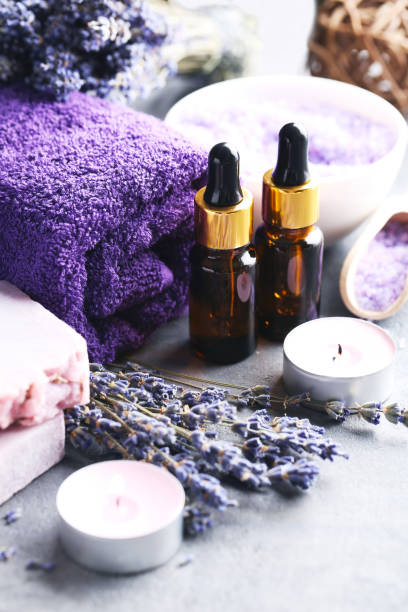 istock Lavender oil with soap and flowers on grey table 667824122